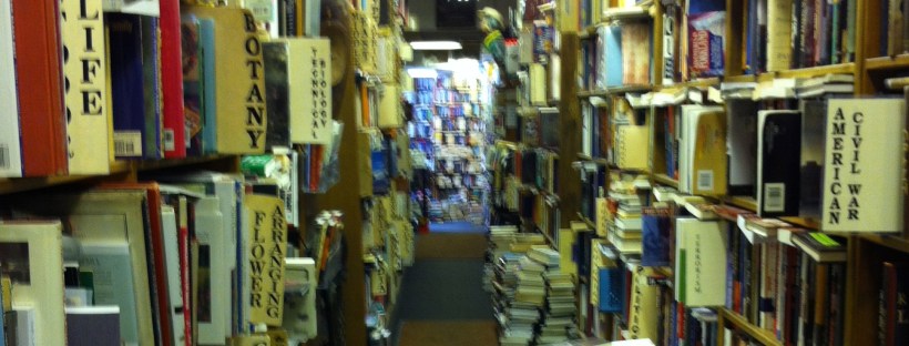 A photo of overstuffed bookshelves in a used bookstore.